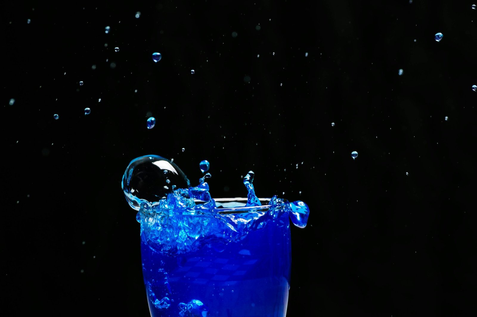 A captivating splash of bright blue liquid against a dark background, showcasing dynamic motion and vibrant energy.